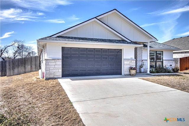 ranch-style home with a garage, concrete driveway, stone siding, and fence