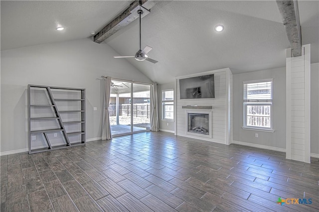 unfurnished living room featuring a ceiling fan, wood finish floors, vaulted ceiling with beams, and a fireplace