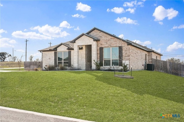 view of front of home with stone siding, a front lawn, fence, and brick siding