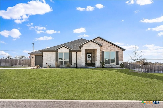 view of front of property with a garage, brick siding, fence, and a front lawn