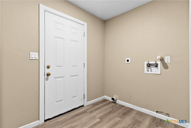 laundry area with electric dryer hookup, light hardwood / wood-style flooring, and washer hookup