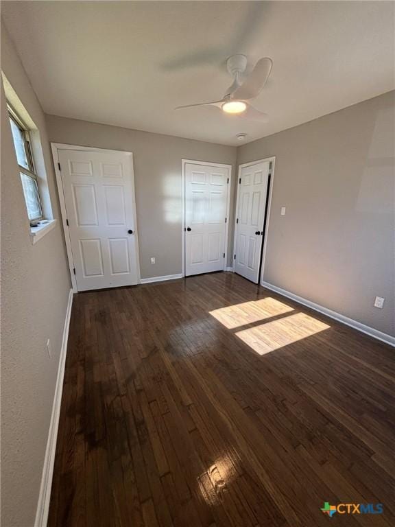 unfurnished bedroom with ceiling fan and dark hardwood / wood-style flooring