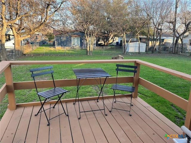 wooden terrace featuring a storage shed and a yard