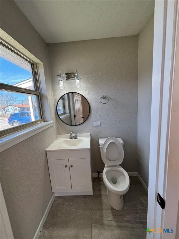 bathroom featuring vanity, toilet, and tile patterned flooring