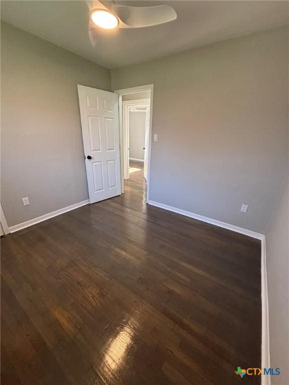 unfurnished room with dark wood-type flooring and ceiling fan