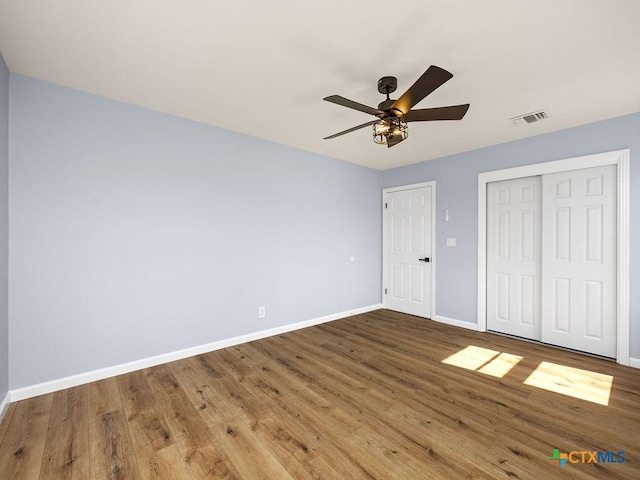 187 Meadow Ave, New Braunfels, TX 78130 - unfurnished bedroom with wood finished floors, a closet, baseboards, and visible vents