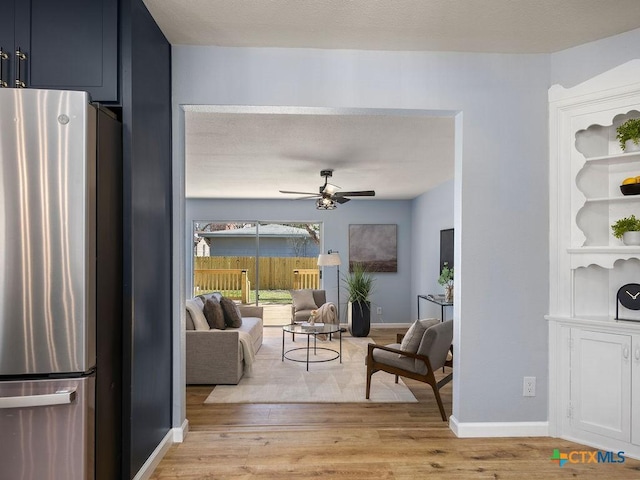 187 Meadow Ave, New Braunfels, TX 78130 - living room featuring baseboards, a textured ceiling, ceiling fan, and light wood-type flooring