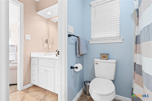 bathroom with baseboards, toilet, tile patterned floors, and vanity