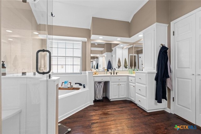 bathroom featuring a bath, vanity, wood finished floors, and a shower stall