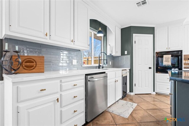 kitchen with white cabinets, visible vents, oven, a sink, and stainless steel dishwasher