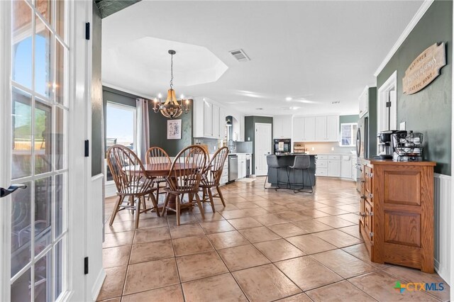 dining space featuring ornamental molding, visible vents, an inviting chandelier, and light tile patterned floors