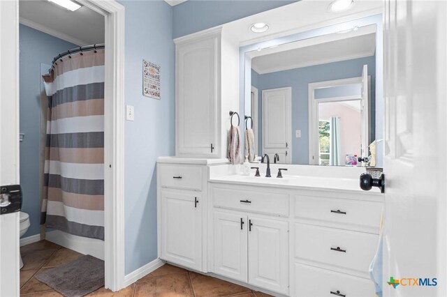 bathroom featuring baseboards, ornamental molding, toilet, tile patterned floors, and vanity