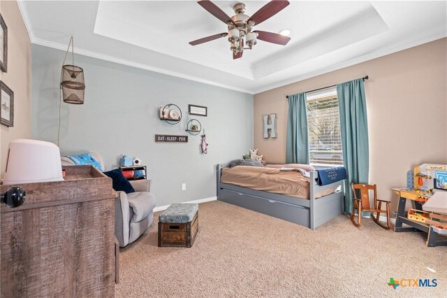 bedroom featuring carpet, a ceiling fan, a raised ceiling, baseboards, and ornamental molding