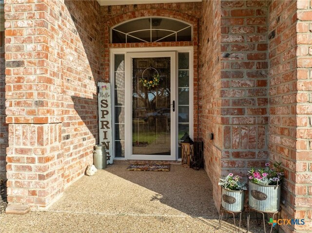 doorway to property featuring brick siding