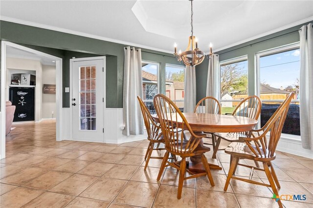 dining room featuring light tile patterned floors, ornamental molding, and an inviting chandelier
