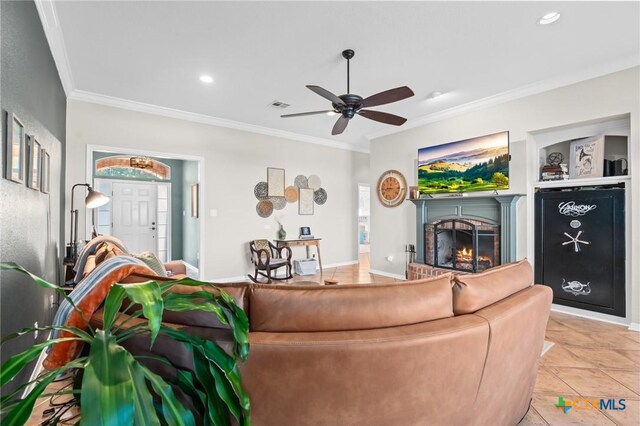 living room featuring visible vents, crown molding, a brick fireplace, ceiling fan, and light tile patterned floors