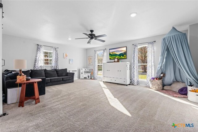 living room with carpet flooring, a ceiling fan, recessed lighting, and a wealth of natural light