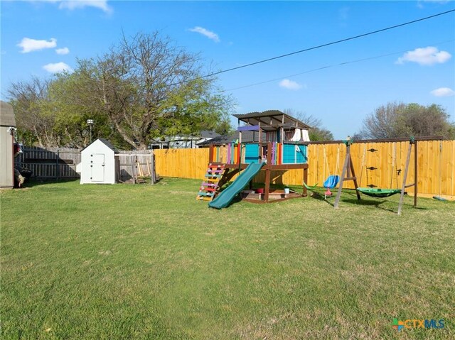 view of play area with a fenced backyard, a shed, an outbuilding, and a yard