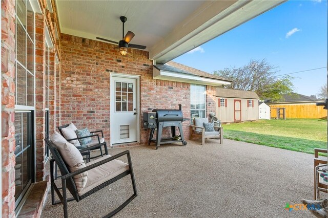 view of patio / terrace featuring an outbuilding, grilling area, a ceiling fan, and a shed