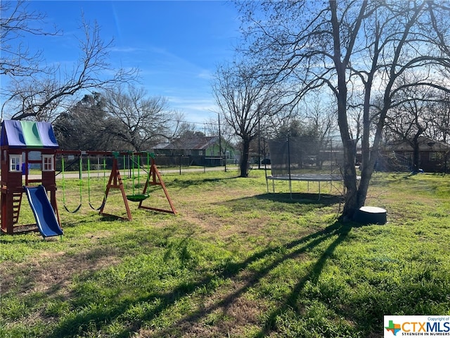 view of yard with a playground and a trampoline