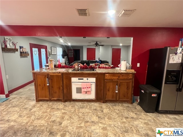 kitchen featuring white oven, stainless steel fridge with ice dispenser, ceiling fan, and black electric cooktop