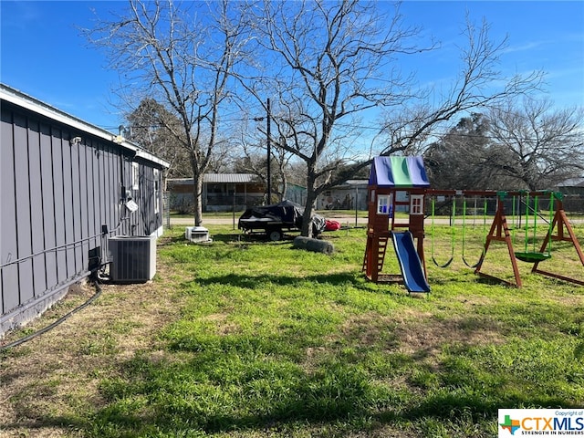 view of yard with central air condition unit and a playground