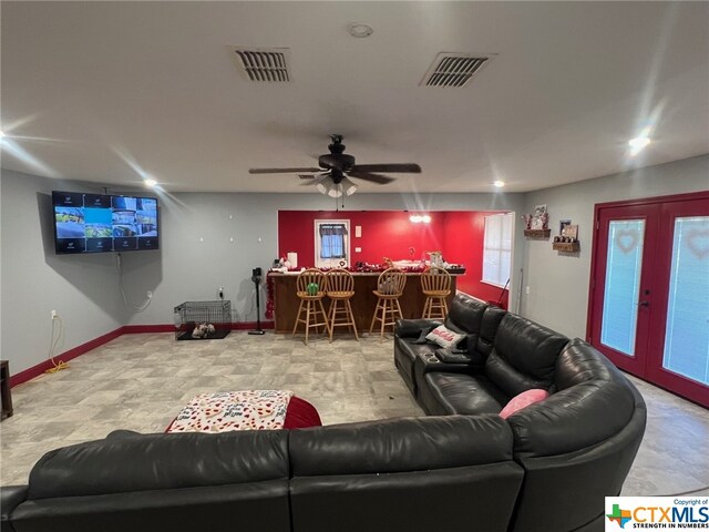 living room featuring ceiling fan and bar area