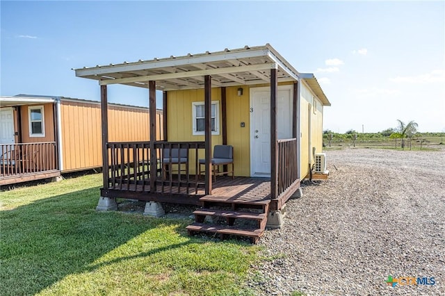 143 S Quailrun Ave, Port Lavaca, TX 77979 - rear view of house with a wooden deck, a yard, and an outbuilding