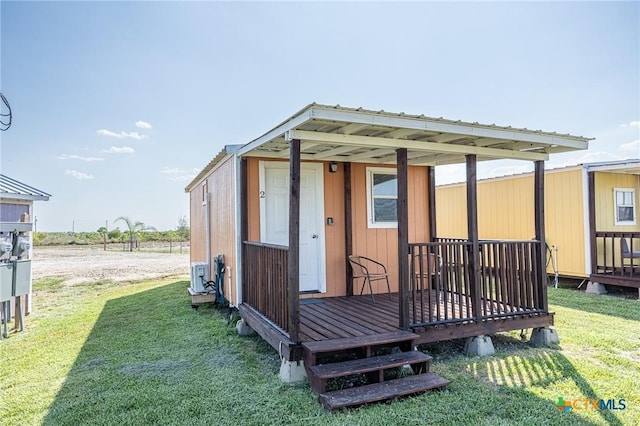 143 S Quailrun Ave, Port Lavaca, TX 77979 - rear view of house featuring an outbuilding, a lawn, and a wooden deck