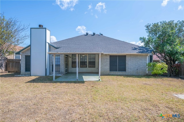 back of property with a lawn and a patio