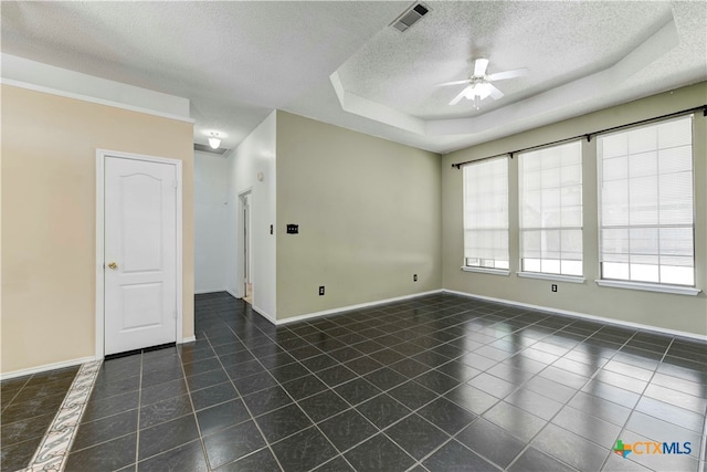 spare room featuring ceiling fan, a textured ceiling, a raised ceiling, and dark tile patterned flooring