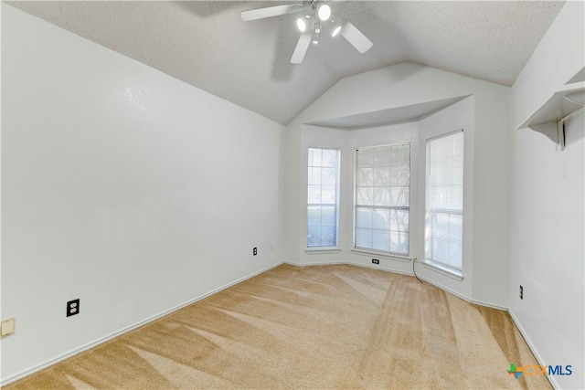 carpeted empty room with lofted ceiling, a textured ceiling, and ceiling fan