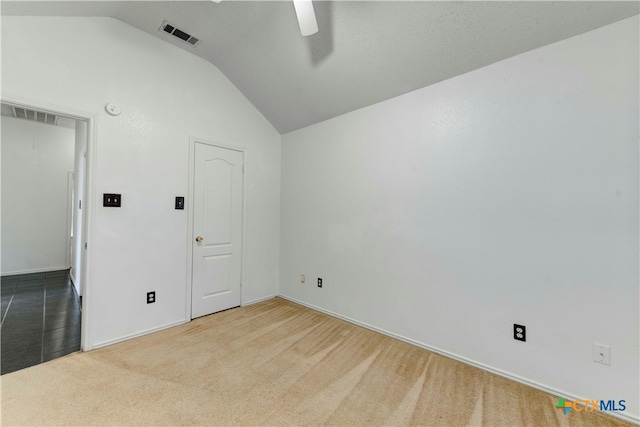 carpeted empty room featuring ceiling fan and vaulted ceiling