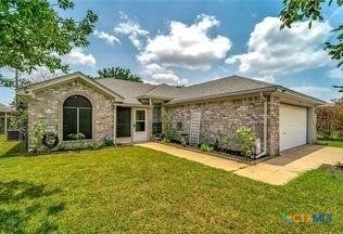 ranch-style house with a front yard and a garage