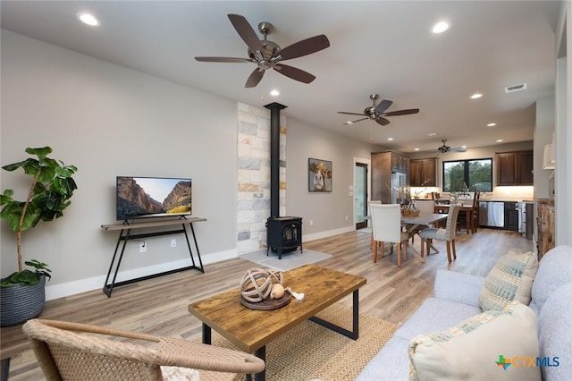 living room with light hardwood / wood-style flooring and a wood stove