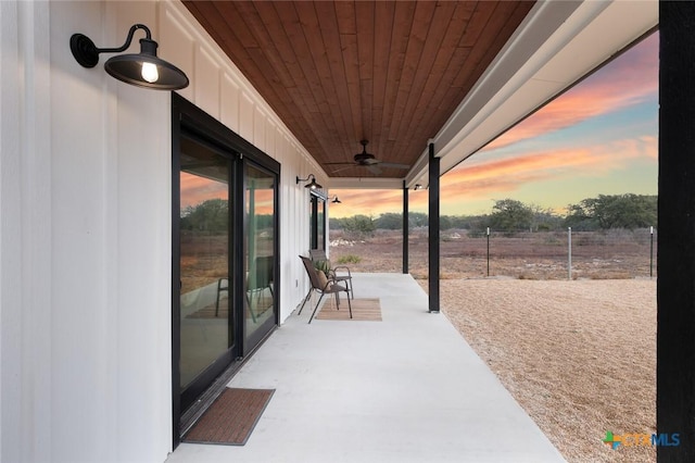 patio terrace at dusk featuring ceiling fan