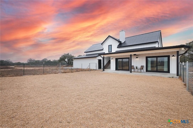 back house at dusk with a patio