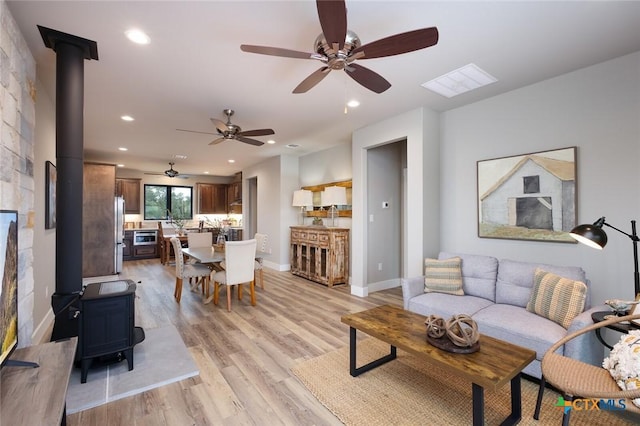 living room with light hardwood / wood-style flooring and a wood stove