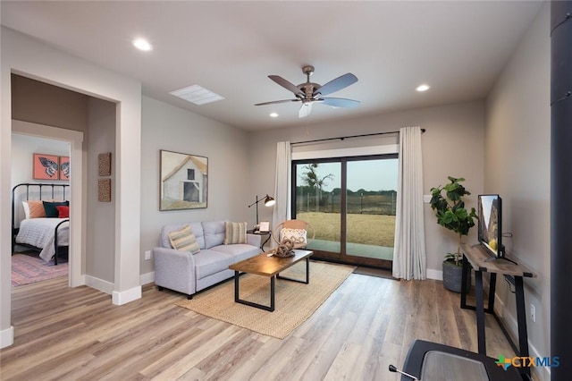 living room featuring light hardwood / wood-style floors and ceiling fan