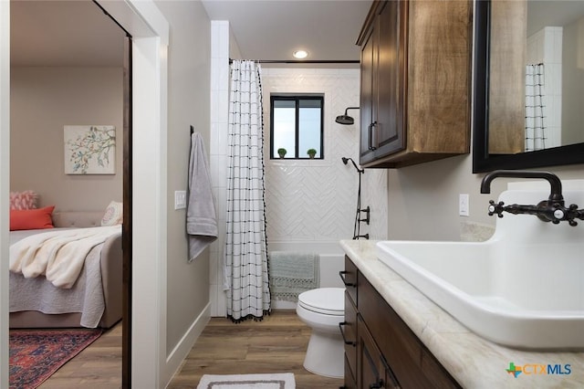 bathroom featuring wood-type flooring, toilet, a shower with shower curtain, and vanity