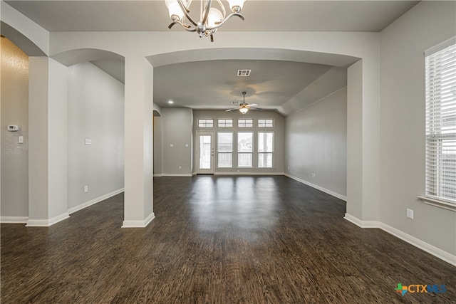 spare room with ceiling fan with notable chandelier, a healthy amount of sunlight, and dark hardwood / wood-style floors