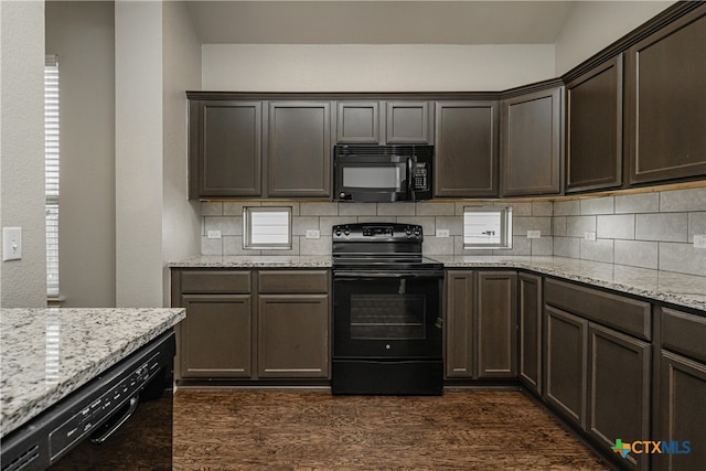 kitchen with dark hardwood / wood-style floors, black appliances, light stone counters, and tasteful backsplash