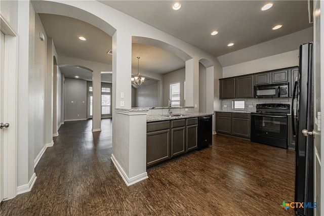 kitchen with dark brown cabinetry, sink, black appliances, dark hardwood / wood-style floors, and decorative light fixtures