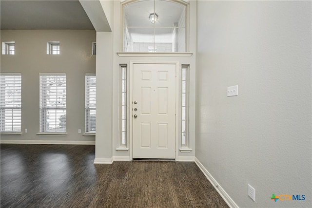 entryway with dark wood-type flooring and a high ceiling