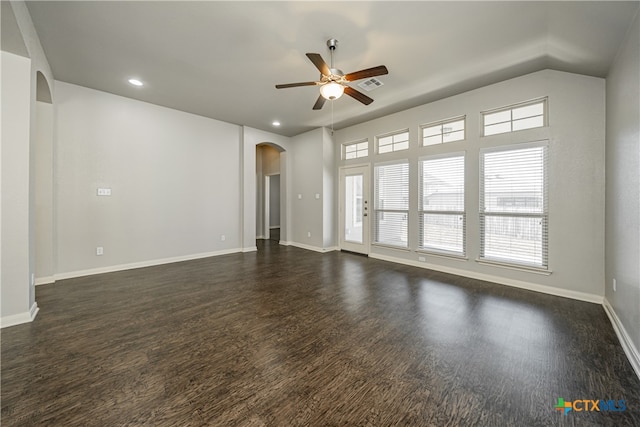 empty room with ceiling fan, dark hardwood / wood-style floors, and lofted ceiling