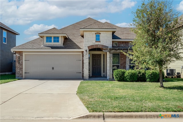 view of front of home featuring a garage, cooling unit, and a front yard