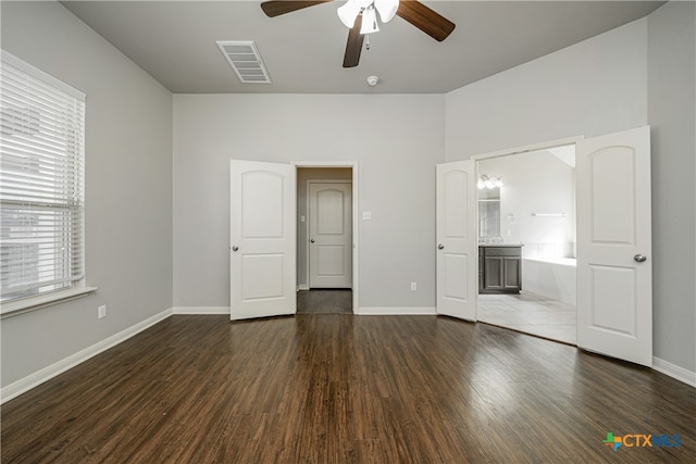 unfurnished bedroom with ensuite bathroom, ceiling fan, and dark hardwood / wood-style flooring