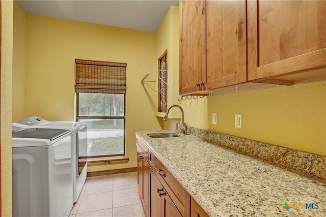 laundry room with cabinets, separate washer and dryer, sink, and light tile patterned floors