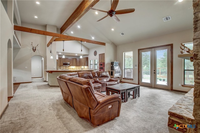 carpeted living room featuring ceiling fan, beamed ceiling, french doors, and high vaulted ceiling