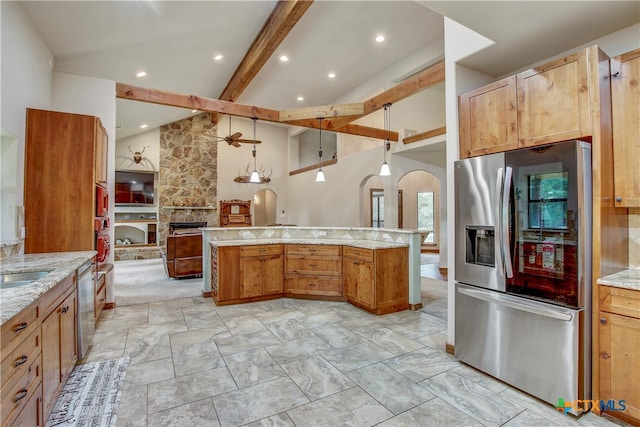 kitchen with appliances with stainless steel finishes, light stone countertops, decorative light fixtures, a fireplace, and vaulted ceiling with beams